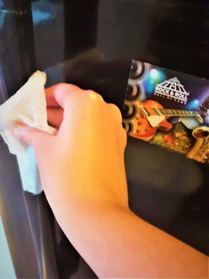 Cleaning the handle of a fridge.