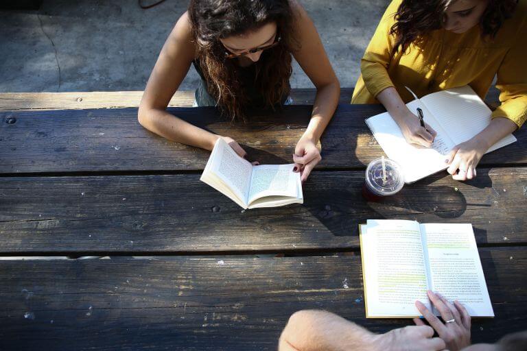 Group of people reading and writing.